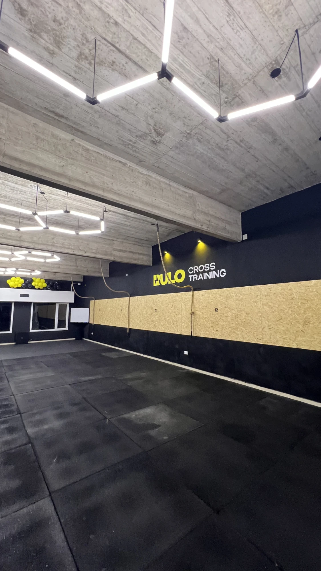 Pared con el logo de Rulo Cross Training y cuerdas para trepar